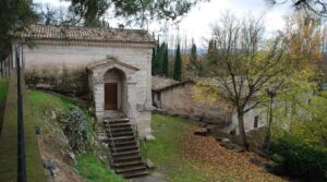 Veduta frontale del Tempietto sul Clitunno, edificio sacro in stile classico con colonne e timpano, immerso nel verde umbro