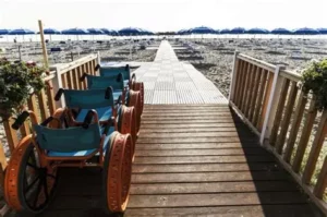 Sedie a ruote in alluminio, progettate per muoversi agevolmente anche sulla sabbia e sulla passerella che permette di arrivare direttamente al mare